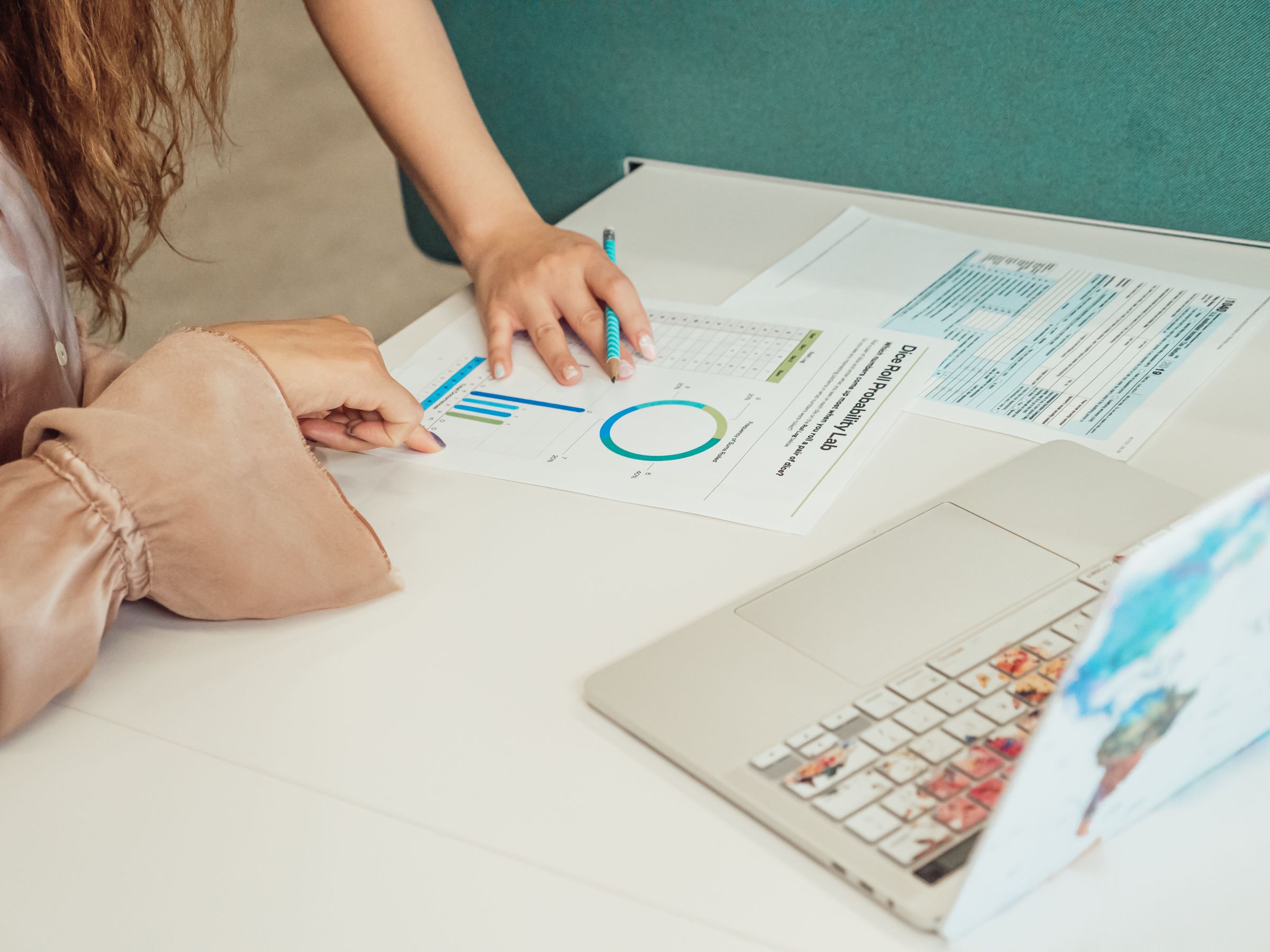 Two researchers reviewing charts and documents together at a desk